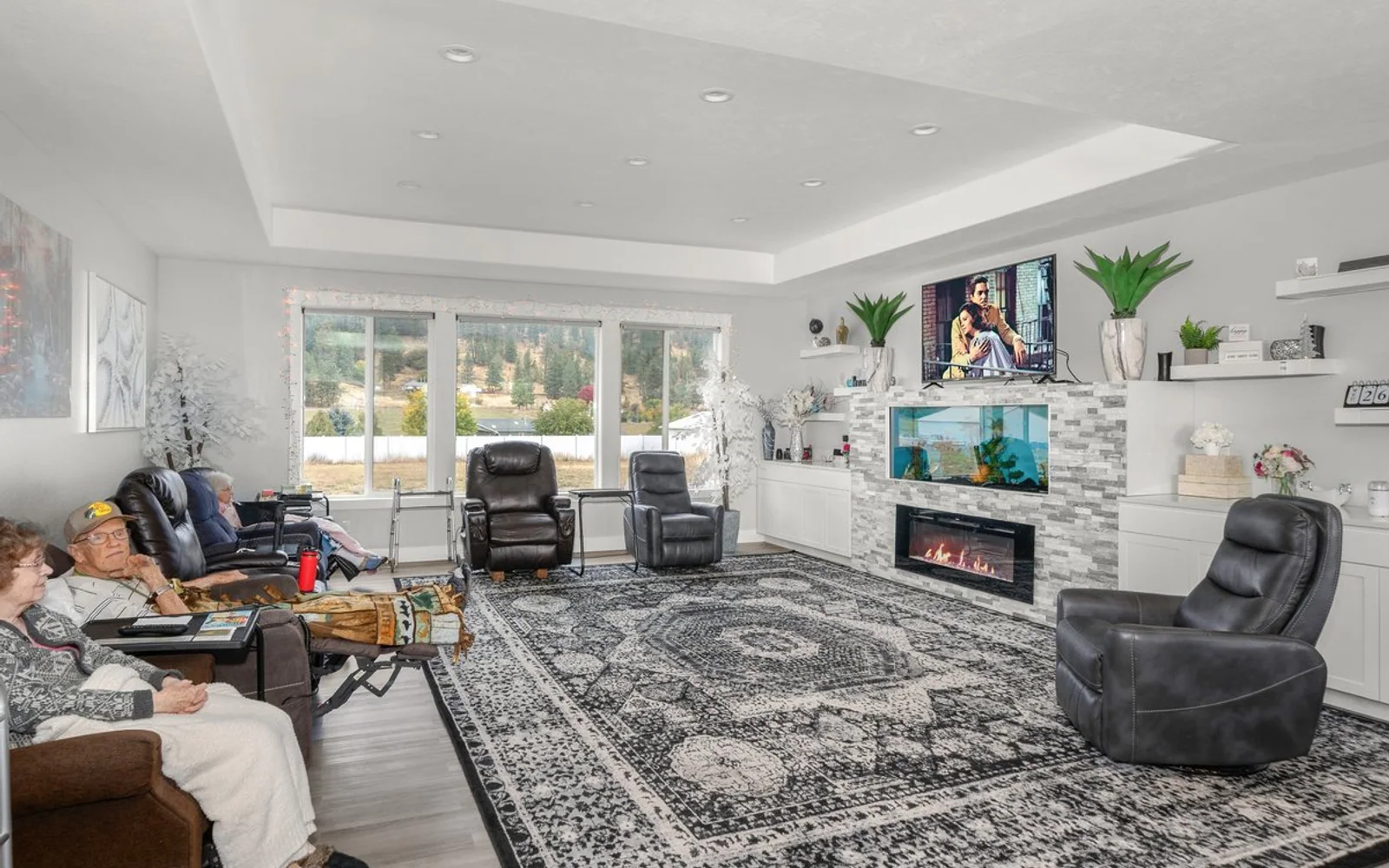 Residents relaxing in the bright shared living room at A+ Quality Adult Family Home