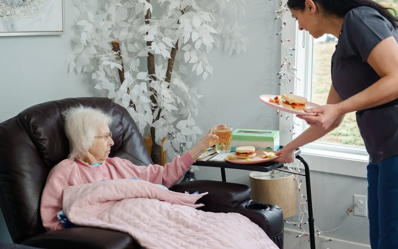 Caregiver serving a meal to a resident at A+ Quality Adult Family Home