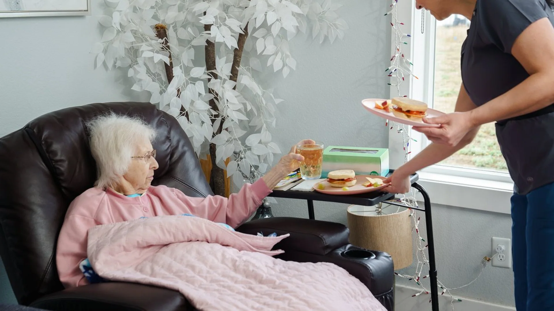 Caregiver serving a meal to a resident at A+ Quality Adult Family Home